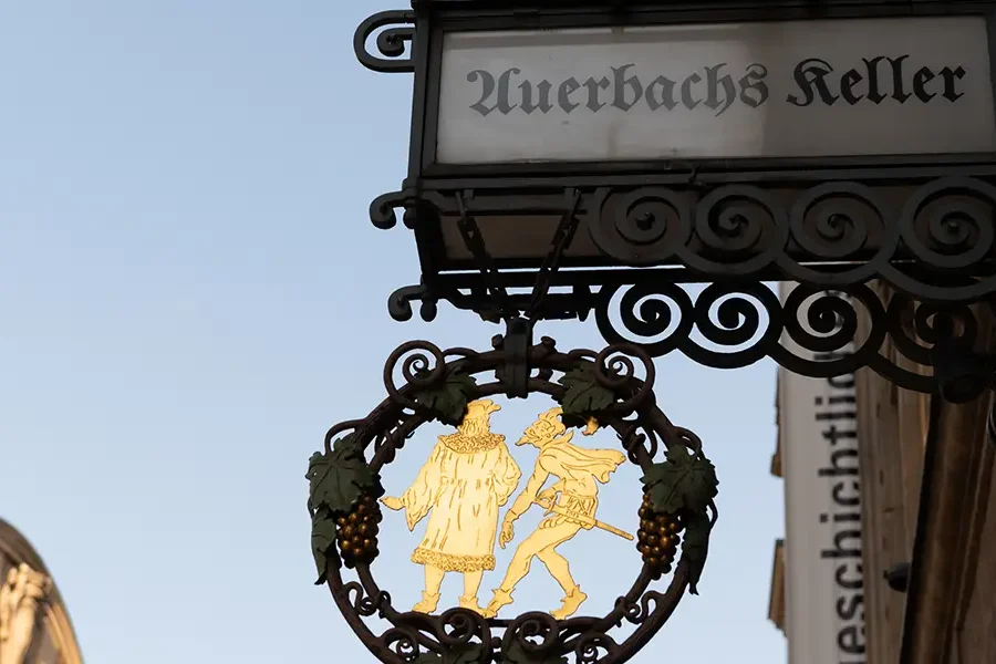 Schmiedeeisernes Schild von Auerbachs Keller mit Figuren von Faust und Mephisto in Leipzig.